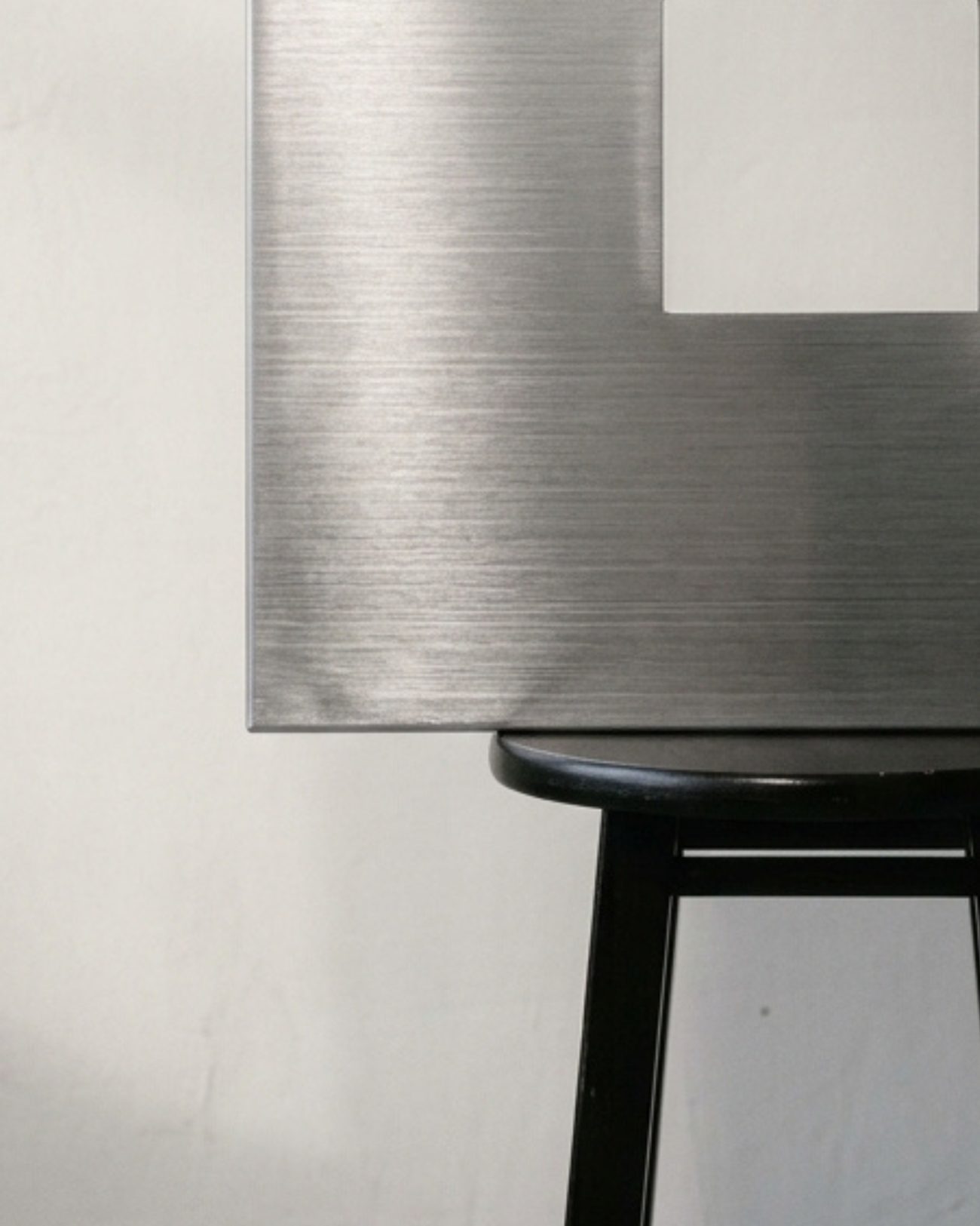 Pieza de aluminio cepillado apoyada en un banco negro
